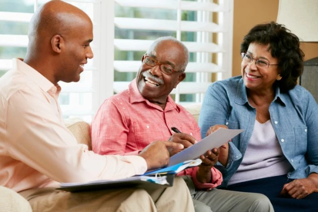 Financial Advisor Talking To Senior Couple At Home Financial Advisor Talking To Senior Couple At Home
